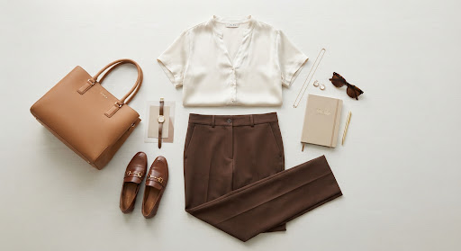 Ivory silk blouse paired with tailored brown trousers